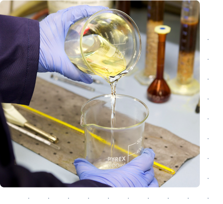 oil being tipped from one beaker to another in lab