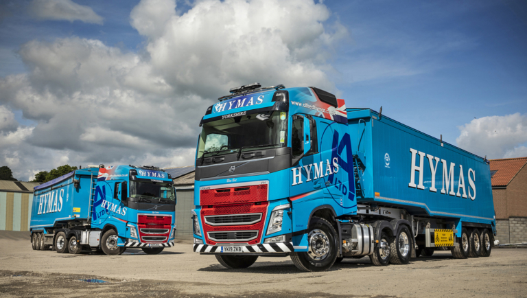 2 blue Alfred Hymas lorries with branded trailers