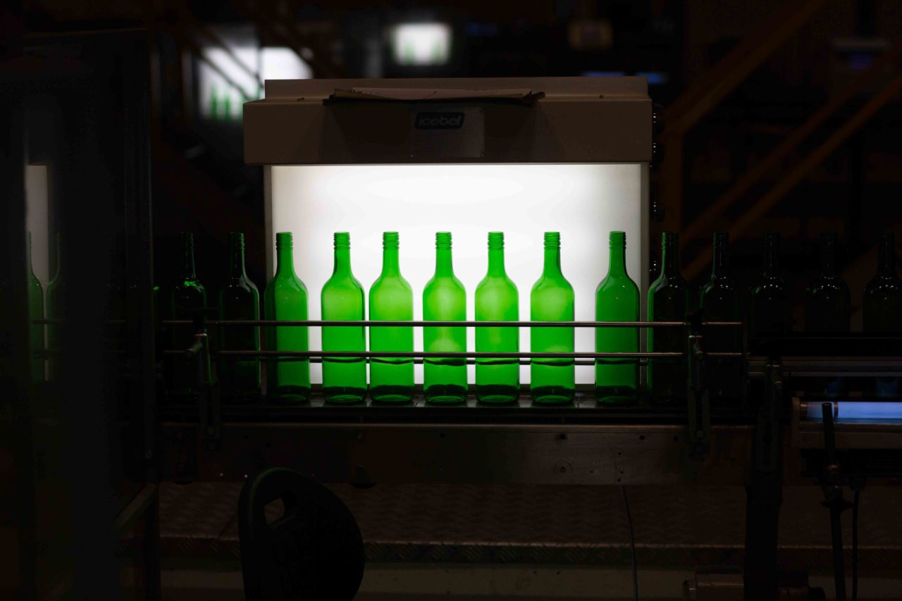 Green ENCIRC bottles on conveyor belt